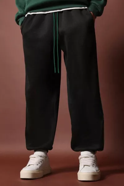 سروال رياضي رجالي أسود موسمي بتفاصيل شريط خيط مزدوج وجيب واسع الحجم