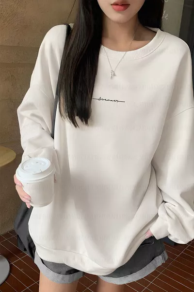 سويت شيرت بولار واسع ومريح للنساء، بكرة صفراء وياقة دائرية وصبغة كريمة بيضاء مكسورة مطبوع عليها كلمة Dreamer