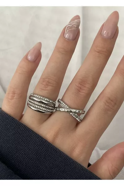 زوج خواتم فضية اللون مزينة بأحجار الزركون، أحدها متقاطع والآخر مستوي