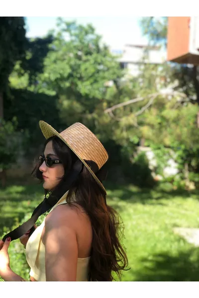 Chapeau en paille à cordon noir noué pour affiner la silhouette, pouvant être repassé