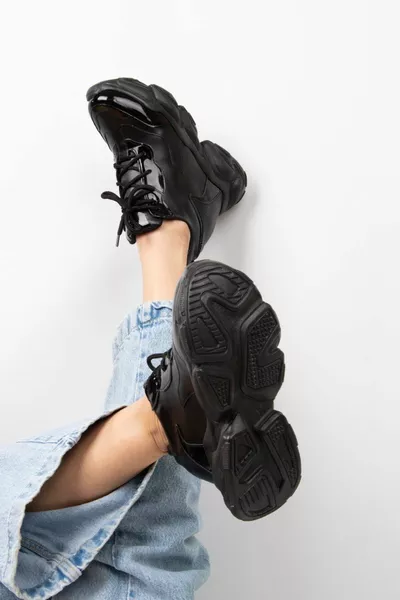 حذاء رياضي نسائي من الجلد الأسود اللامع بكعب مبطن