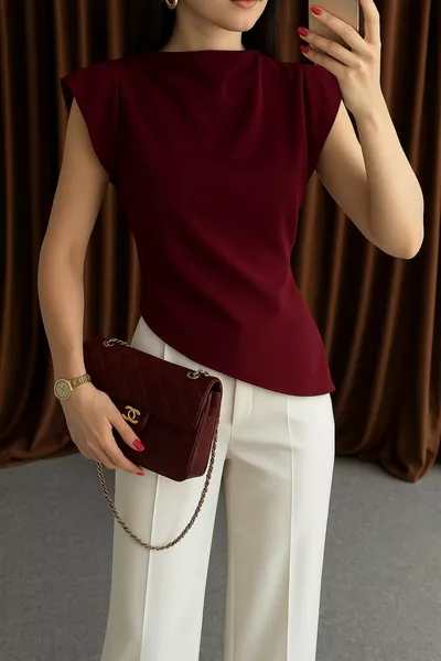 Blouse à fermeture éclair au dos avec épaules structurées et coupe asymétrique