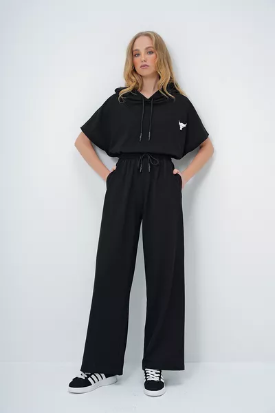 طقم نسائي سترة سوداء بغطاء للرأس وتوب قصير واسع مع بنطلون ذو جيبين مزدوجين 