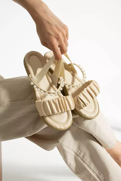 صندل بيج مرصع باللؤلؤ بمطاط