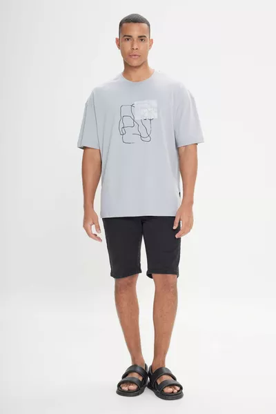 تي شيرت رجالي فضفاض رمادي اللون بقصة واسعة و ياقة دائرية، مصنوع من ٪ قطن ومطبوع