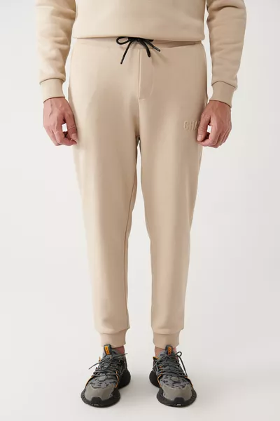 Pantaloni da tuta uomo beige con coulisse in vita, felpati a tre fili, fondo gamba con elastico 