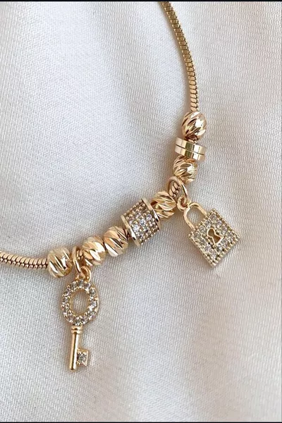 سوار نسائي من الفولاذ مع تفاصيل زركون ومفتاح قفل ذهبي