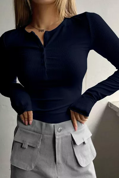 بلوزة نسائية واحدة باللون الأزرق الداكن، بياقة دائرية وأزرار مخفية، بأكمام طويلة وقماش مضلع