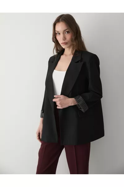 سترة بليزر نسائية مخططة بالأسود مبطنة مع تفاصيل على الأكمام