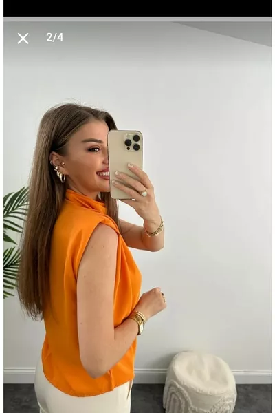 بلوزة نسائية بياقة عميقة وكتفين مبطنتين وقصة فضفاضة