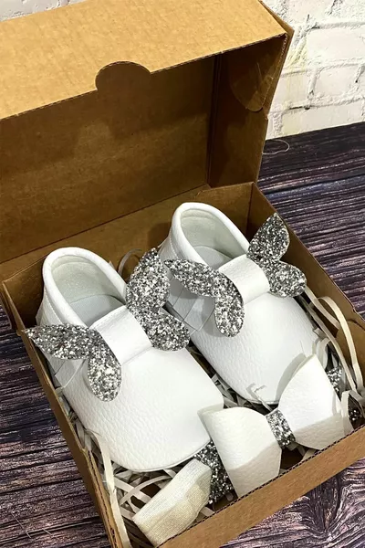 حذاء طفل أبيض وقطعة رأس