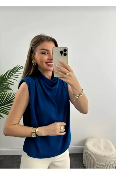 بلوزة نسائية بياقة منسدلة وكتفين مبطنتين وقصة فضفاضة