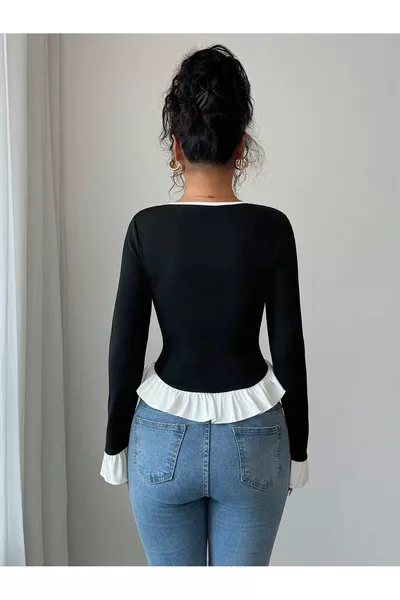 أسود بأكمام طويلة وياقة على شكل حرف V مع تفاصيل بيضاء