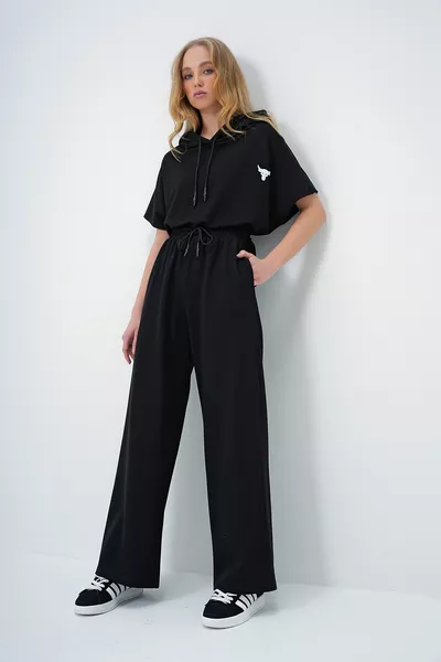 طقم نسائي سترة سوداء بغطاء للرأس وتوب قصير واسع مع بنطلون ذو جيبين مزدوجين 