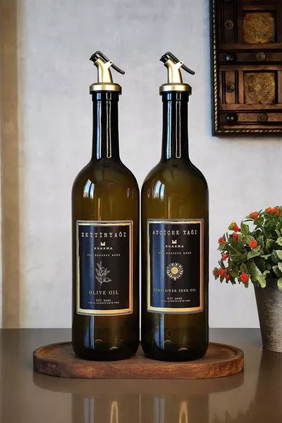 زجاجتي زيت زيتون وزيت نباتي بكوب خشبي باللون الكهرماني والأسود والذهبي