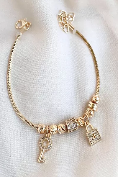 سوار نسائي من الفولاذ مع تفاصيل زركون ومفتاح قفل ذهبي