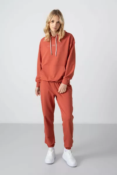 Kaneelkleurige oversized dames joggingpak met capuchon, buidelzak en elastische boorden - 