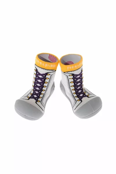 Nuove scarpe da ginnastica gialle a piedi nudi primo passo