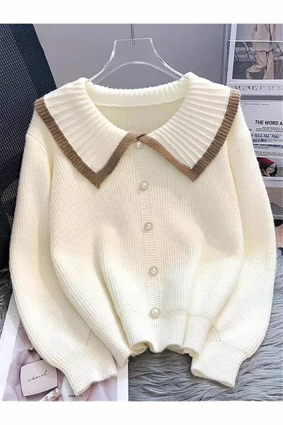 كنزة صوفية بقوام ناعم وتفاصيل أزرار باللون الكريم