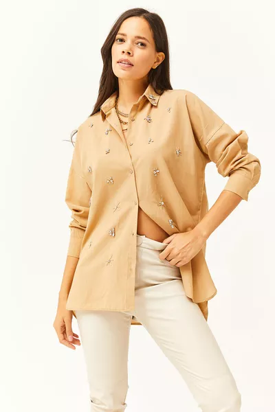 Chemise femme à col chameau avec devant orné de pierres et base ovale en tissu tissé 