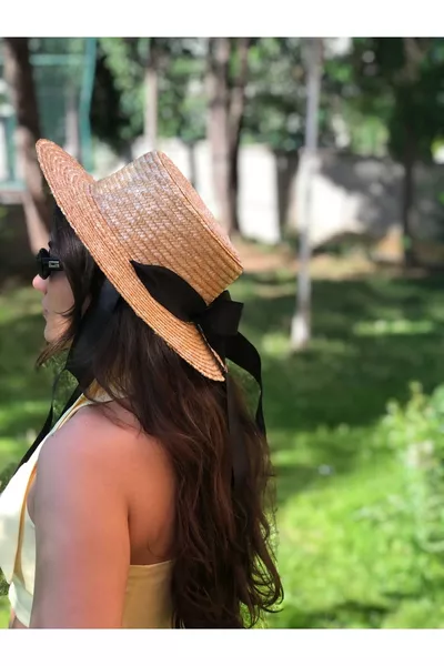 Chapeau en paille à cordon noir noué pour affiner la silhouette, pouvant être repassé