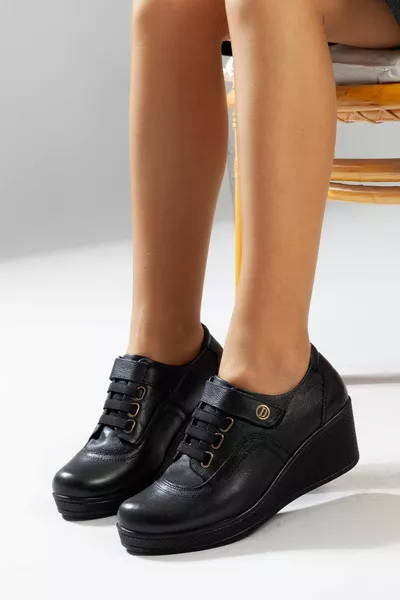 أحذية سوداء للعظام من جلد طبيعي للسيدات (1 مقاس أكبر)