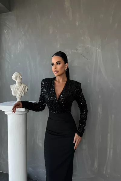 فستان أسود بتصميم برقبة على شكل كروس ومرصّع بالترتر