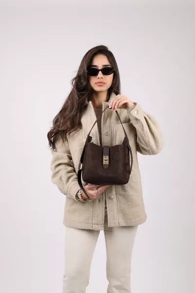 حقيبة نسائية من جلد الغزال باللون البني الداكن مع قفل ذهبي وتفاصيل إكسسوار، بحمالة قابلة للتعديل يمكن حملها باليد أو على الكتف