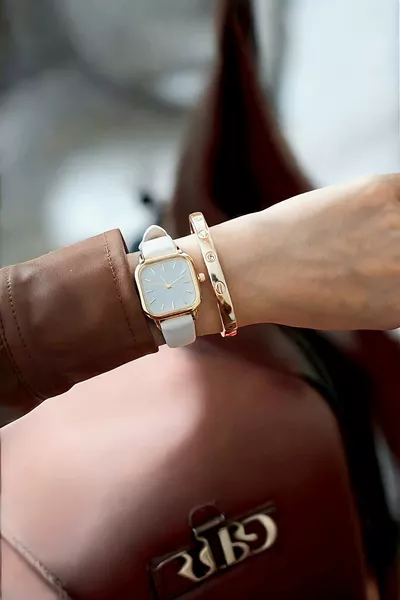 ساعة عتيقة بحزام جلدي، علبة ذهبية، باللون الأبيض وأرقام رومانية