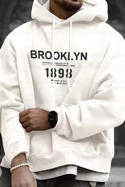 هودي رجالي بأكمام واسعة، بحجم كبير، منسوج بخيط ثلاثي، مبطن بالفرو، بلون أبيض مائل للكريم  مطبوع ومزود بغطاء رأس