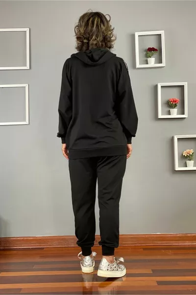 Tuta nera con dettaglio in pietra sulla spalla e sulla 