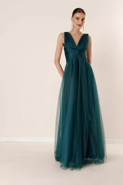 فستان طويل من التول بفتحة رقبة على شكل V في الخلف بقصة منخفضة وبطانة درابيه في الأمام بلون زمردي