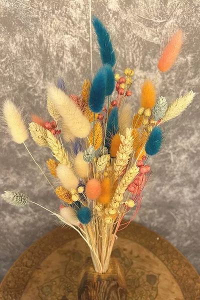 ترتيب زهرة زنبق مجففة مع زخارف وفازة بلون التركواز