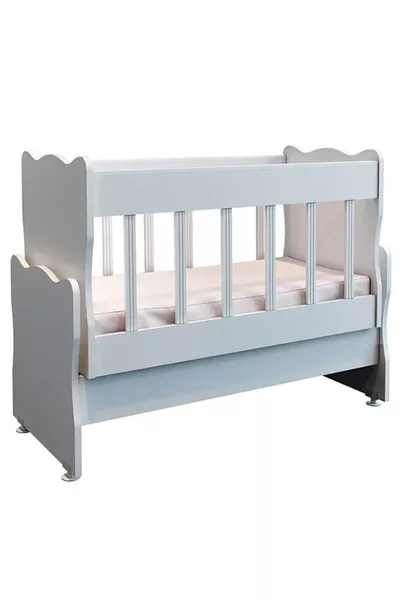 سرير أطفال خشبي أبيض يتأرجح بجانب الأم